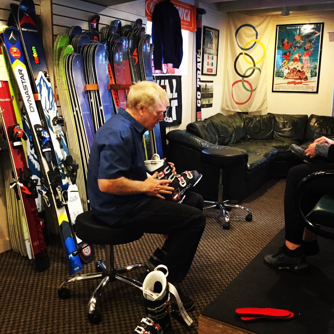 Founder Buck in the shop holding a ski boot